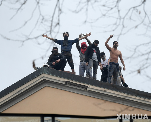 이탈리아 정부가 신종 코로나바이러스 감염증(코로나19) 확산을 막기 위해 재소자의 가족 면회를 제한하는 결정을 내리자 9일(현지시간) 밀라노의 산비토레 교도소에서 재소자들이 교도소 지붕 위에 올라가 항의 시위를 벌이고 있다. (출처: 뉴시스)