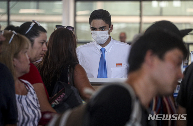 3일(현지시간) 칠레 수도 산티아고의 아르투로 메리노 베니테스 국제공항에서 마스크를 쓴 한 항공사 직원이 손님을 응대하고 있다(출처: 뉴시스)