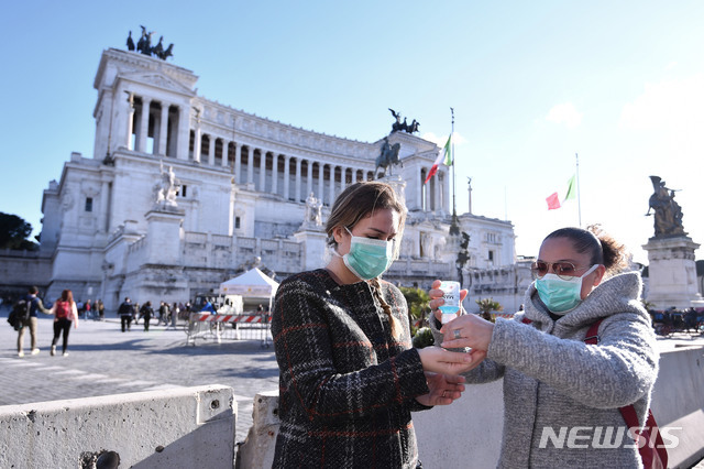 8일(현지시간) 이탈리아 로마 베네치아 광장에서 마스크를 쓴 여성들이 손을 소독하고 있다. (출처: 뉴시스)