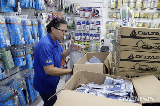 26일(현지시간) 브라질 상파울루의 한 의료용품점에서 이곳 직원이 신종 코로나바이러스 감염증(코로나19) 예방을 위해 판매할 마스크를 분류하고 있다. (출처: 뉴시스)