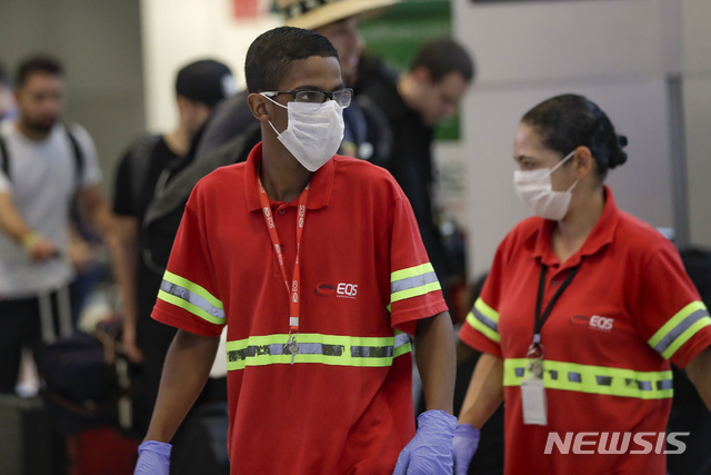 브라질 상파울루 국제공항에서 신종 코로나바이러스 감염증(코로나19) 확산 사태에 대비해 공항 직원들이 마스크를 착용한 채 일하고 있다(출처: 뉴시스)