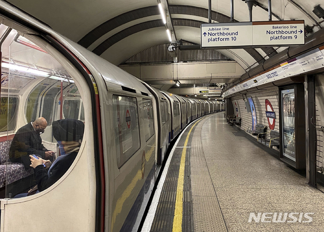 영국 정부가 신종 코로나바이러스 감염증(코로나19) 확산을 줄이기 위해 불가피한 경우에만 이동을 허용한 가운데 25일(현지시간) 마스크를 쓴 한 남성이 런던의 한 지하 역에서 열차에 앉아 출발을 기다리고 있다. (출처: 뉴시스)