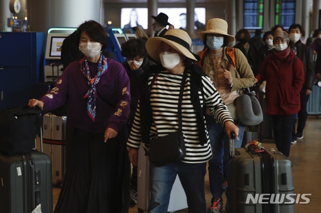 23일(현지시간) 이스라엘 텔아비브의 벤구리온 국제공항에서 마스크를 쓴 한국인 여행객들이 짐을 끌고 이동하고 있다. 한국 이스라엘 성지순례단이 신종 코로나바이러스 감염증(코로나19) 집단 확진 판정을 받은 가운데 이스라엘 외교부는 