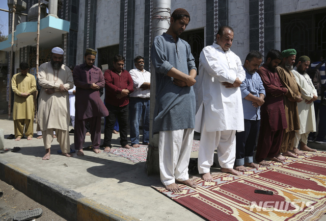 3일(현지시간) 파키스탄 하이데라바드의 한 사원 밖에서 마스크를 하지 않은 이슬람 신자들이 기도하고 있다. (출처: 뉴시스)