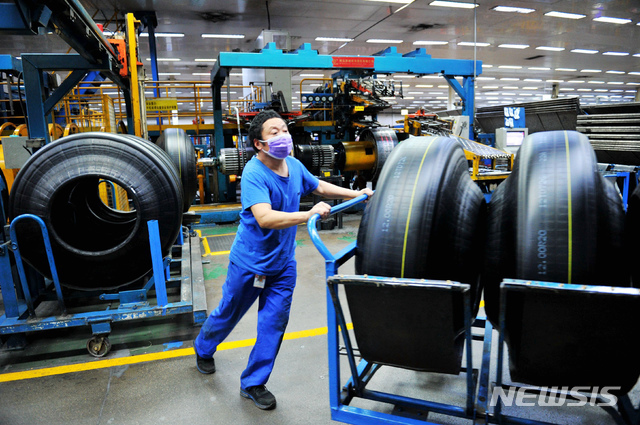 중국 산둥성 칭다오시에 위치한 공장에서 마스크를 낀 노동자가 제조된 타이어를 옮기고 있다. (출처: 뉴시스)