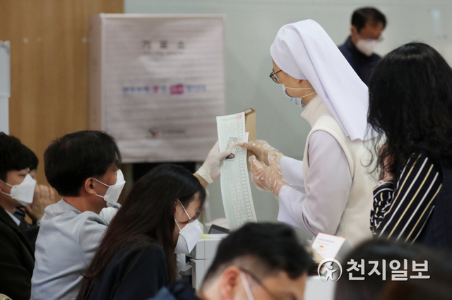 [천지일보=박준성 기자] 제21대 국회의원 선거의 사전투표가 시작된 10일 오전 서울 국회 여의도 여의동 사전투표소를 찾은 한 수녀가 투표용지를 받고 있다. ⓒ천지일보 2020.4.10