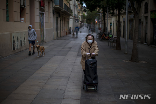 7일(현지시간) 스페인 바르셀로나의 한 거리에서 한 노인이 카트를 밀며 이동하고 있다(출처: 뉴시스)