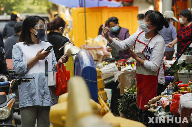 16일(현지시간) 중국 후베이성 우한의 상가에서 마스크를 쓴 시민들이 식료품을 사고 있다. 중국 내 신종 코로나바이러스 감염병(코로나19)의 확산이 누그러들면서 우한에서는 생활이 점차 일상으로 돌아오고 있다(출처: 뉴시스)