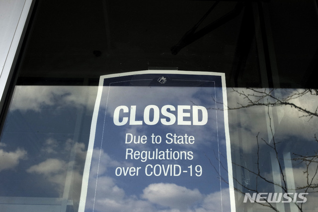 [더햄=AP/뉴시스] 22일 미국 매사추세츠주 도시의 아웃도어 몰 가게에 코로나 19로 문을 닫는다는 표지가 붙어 있다.  2020. 4. 23.