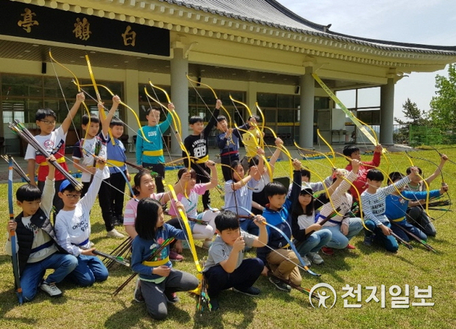 지난해 장성군 홍길동 테마파크 국궁장을 찾은 초등학생들이 활을 들고 포즈를 취하고 있다. (제공: 장성군) ⓒ천지일보 2020.4.28