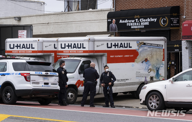 29일(현지시간) 미국 뉴욕 경찰(NYPD)이 브루클린의 앤드루 T. 클래클리 장례식장에 세워진 두 대의 트럭 앞에 서 있다. 이 트럭에서 부패한 시신 수십 구가 발견돼 경찰이 조사 중이다. (출처: 뉴시스)