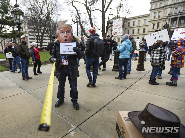 미 미시간주 랜싱 시내에서 시민들이 그레첸 위트머 미시간주지사가 신종 코로나바이러스 감염증(코로나19) 확산 예방을 위해 내린 자택 체류 명령에 반대하는 시위를 벌이고 있다. (출처: 뉴시스)