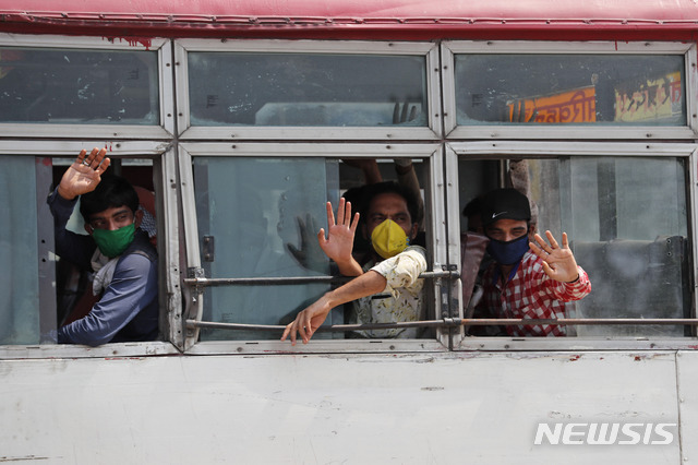 6일(현지시간) 인도 구자라트주에서 열차 편으로 고향인 우타르프라데시주 프라야그라즈에 도착한 이주노동자들이 버스에 올라 자신들의 마을로 향하면서 손을 흔들고 있다(출처: 뉴시스)