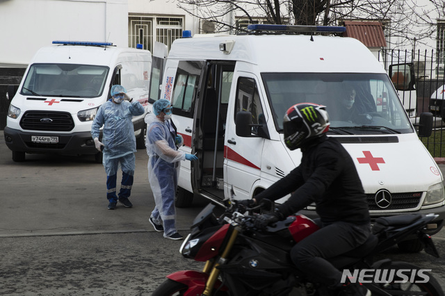9일(현지시간) 러시아 모스크바의 한 병원 근처에서 의료진이 앰뷸런스 앞에 서 있다(출처: 뉴시스)