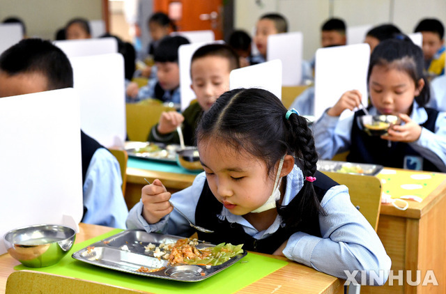 지난 11일 중국 산시성에 있는 후자이먼 초등학교에서 1학년 학생들이 칸막이가 있는 책상에서 점심을 먹고 있다. (출처: 뉴시스)