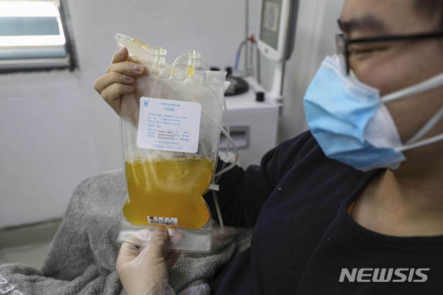 지난 2월 18일 중국 후베이성 우한의 한 병원에서 코로나19에 걸렸다가 회복된 의사가 자신의 혈장을 들고 있다. (출처: 뉴시스)