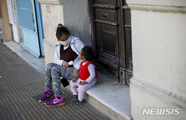 16일(현지시간) 아르헨티나 부에노스아이레스에서 모녀가 집 앞에 앉아있다. (출처: 뉴시스)