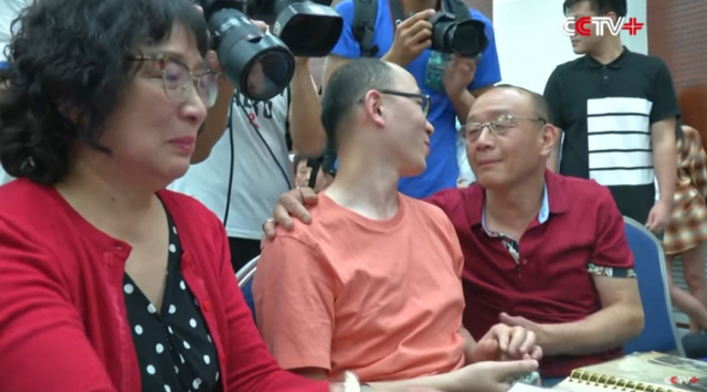 32년 전 두 살 때 납치된 마오인(가운데)이 지난 18일 중국 산시성 시안에서 열린 기자회견 도중 친부모와 감격의 상봉을 하고 있다. (출처: CCTV 방송 캡처)