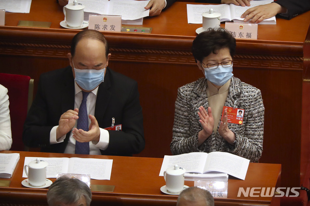 22일(현지시간) 중국 베이징 인민대회당에서 중국 최대 정치 행사인 전국인민대표회의(전인대)가 열리고 있는 가운데 캐리 람 홍콩 행정장관(오른쪽)이 신종 코로나바이러스 감염증(코로나19)을 막기 위해 마스크를 쓴 채 박수를 치고 있다. (출처: 뉴시스)
