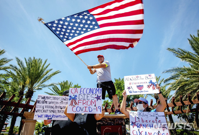 3일(현지시간) 미 캘리포니아주 랜초 쿠카몽가에서 신종 코로나바이러스 감염증(코로나19)과 관련한 캘리포니아주의 자택 체류 명령에 반대하는 시위대가 미국 국기를 흔들며 시위하고 있다. (출처: 뉴시스)