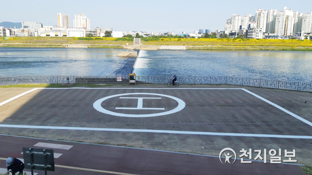 [천지일보 진주=최혜인 기자] 지난 27일 경상대학교병원 앞 남강변 일대에 응급환자 긴급이송을 위한 전용헬기장이 설치를 마치고 모습을 보이고 있다.정재욱 진주시의회 의원은 그동안 본회의 자유발언 등을 통해 “경상대병원은 권역외상센터면서도 병원 앞 둔치에서 긴급환자를 이송하고 있다. 비산먼지·이물질이 날아다니고, 심한 소음으로 주민 불편함과 불안감이 가중되고 있다”며 헬기장 설치를 촉구해왔다.전용헬기장에는 핼리패드와 안내판, 그리고 시민들의 긴급대피를 위한 사이렌 등이 설치됐다. ⓒ천지일보 2020.5.27