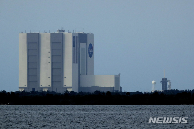 미국의 민간 우주개발사 스페이스X의 유인우주선 '크루 드래건'이 탑재된 팰컨 9 로켓이 26일(현지시간) 플로리다주 케이프 커내버럴의 케네디 우주센터 P39-A 발사대(오른쪽)에 세워져 있다. (출처: 뉴시스)