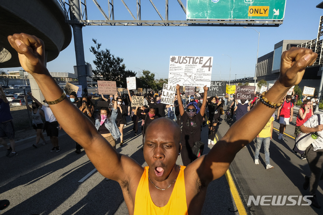 27일(현지시간) 미 캘리포니아주 로스앤젤레스 도심에서 미니애폴리스 흑인 남성 조지 플로이드의 질식사에 대한 경찰의 과잉 진압에 항의하는 시위가 열려 시위대가 행진하고 있다(출처: 뉴시스)