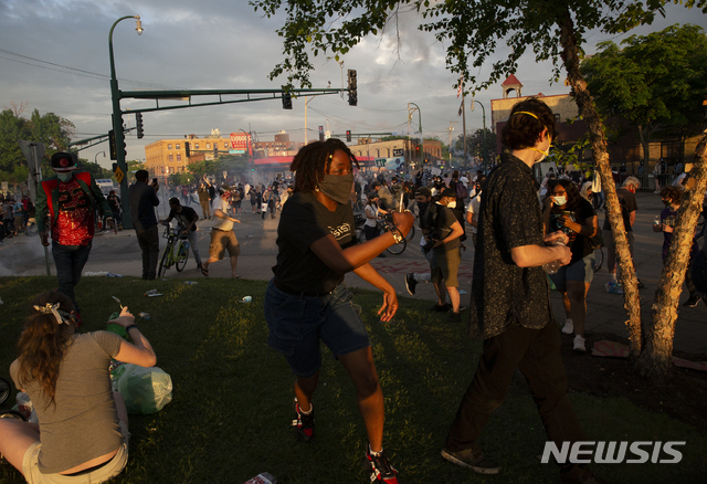 27일(현지시간) 미국 미네소타주 미니애폴리스에서 흑인 사망 사건 규탄 시위가 벌어진 가운데 시위대가 화학 자극제가 배치된 곳에서 달아나고 있다. (출처: 뉴시스)