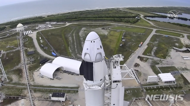 [케이프 커내버럴=나사TV·AP/뉴시스]미국 플로리다주 케이프 커내버럴 소재 케네디우주센터 발사대에 27일(현지시간) 스페이스X의 유인캡슐 '크루 드래건'이 탑재된 로켓이 세워져 있다. 이날 발사는 기상악화로 연기됐다. ⓒ천지일보 2020.5.30