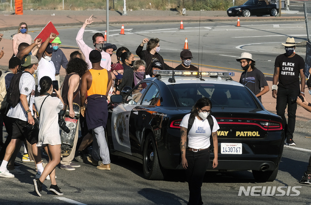 27일(현지시간) 미 캘리포니아주 로스앤젤레스 도심에서 미니애폴리스 흑인 남성 조지 플로이드의 질식사에 대한 경찰의 과잉 진압에 항의하는 시위가 열려 시위대가 고속도로 순찰차를 공격하고 있다(출처: 뉴시스)