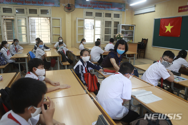 4일(현지시간) 베트남 수도 하노이의 딘꽁 중학교에서 교사가 수업 전 학생들의 체온을 측정하고 있다. (출처: 뉴시스)