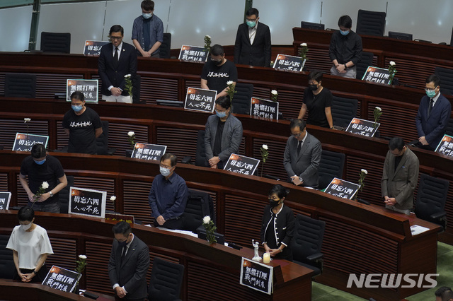 홍콩 입법회에서 4일 민주파 의원들이 자리에서 일어나 31년전 중국 톈안먼 광장에서 학살당한 희생자들을 위해 1분간 추모 묵념을 하고 있다. (출처: 뉴시스)
