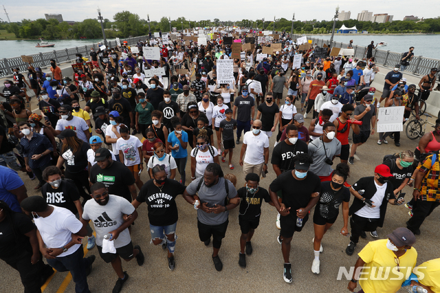 백인 경찰관의 과잉 진압에 사망한 흑인 ‘조지 플로이드’의 죽음을 추모하는 시위대가 5일(현지시간) 미국 미시간주 디트로이트강의 맥아더 다리에서 행진하고 있다. (출처: 뉴시스)