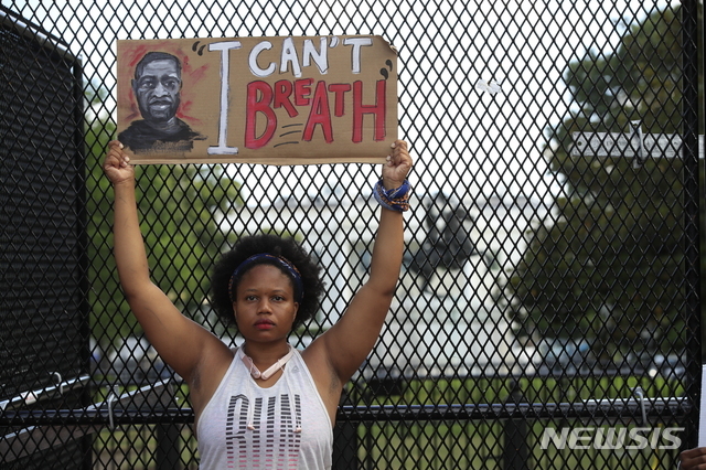 (워싱턴=AP/뉴시스) 5일(현지시간0 미국 워싱턴 백악관 근처에서 미니애폴리스에서 흑인 조지 플로이드가 경찰에 의해 사망한 것에 대해 사람들이 항의하는 가운데 시위자가 팻말을 들고 있다.