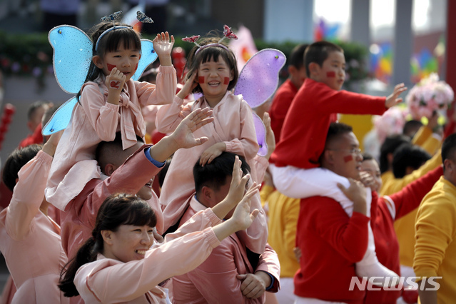 작년 10월 1일(현지시간) 중국 베이징의 톈안먼 광장에서 신중국 건국 70주년 기념 퍼레이드가 열려 부모와 함께 나온 어린이들이 즐거운 표정으로 행진하고 있다. (출처: 뉴시스)