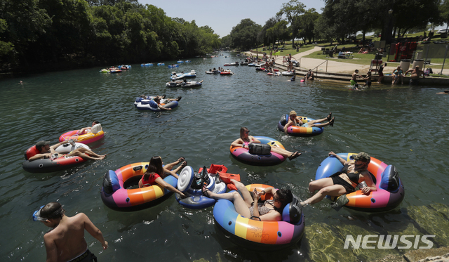 지난달 20일(현지시간) 미 텍사스주 뉴 브라운펠스의 코멀 강에서 튜브를 탄 사람들이 물놀이를 즐기고 있다. 신종 코로나바이러스 감염증(코로나19)으로 폐쇄됐던 공원들이 재개장하면서 많은 텍사스 주민이 야외 활동을 즐기고 있다. (출처: 뉴시스)