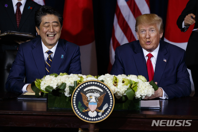 도널드 트럼프(오른쪽) 미국 대통령과 아베 신조 일본 총리가 작년 9월 25일(현지시간) 유엔총회가 열리고 있는 뉴욕의 인터콘티넨탈 호텔에서 미·일 무역협정서에 서명하기 전 웃으며 얘기하고 있다. (출처: 뉴시스)