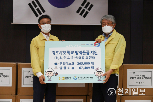 정하영 김포시장(왼쪽)이 24일 마스크 26만 5000장을 김포교육지원청에 전달하고 있다. (제공: 김포시) ⓒ천지일보 2020.6.25