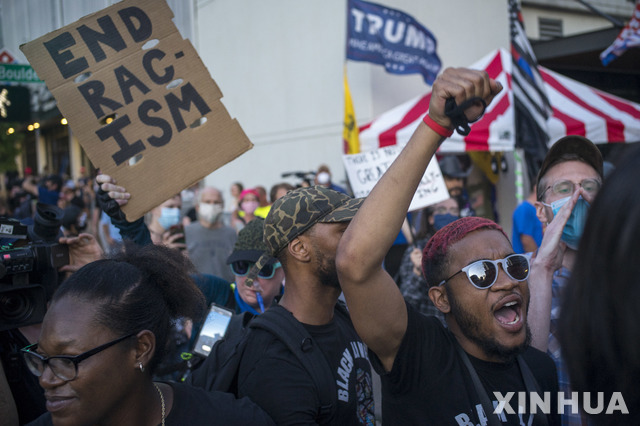 트럼프 미국 대통령이 지난 20일(현지시간) 코로나19 여파로 유세를 중단한 지 약 3개월 만에 미 오클라호마주 털사에서 대선 유세를 재개한 가운데 마스크를 착용하지 않은 주민들이 반트럼프 시위를 벌이고 있다(출처: 뉴시스)