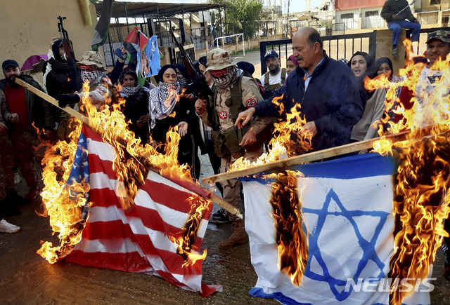지난 1월 29일(현지시간) 레바논 남부 시돈의 한 난민 캠프에서 팔레스타인 사람들과 무장한 남성들이 이스라엘-팔레스타인 분쟁 종식을 위한 백악관의 '중동평화안'에 반대하는 시위를 벌이며 미국과 이스라엘 국기를 불태우고 있다. (출처: 뉴시스)