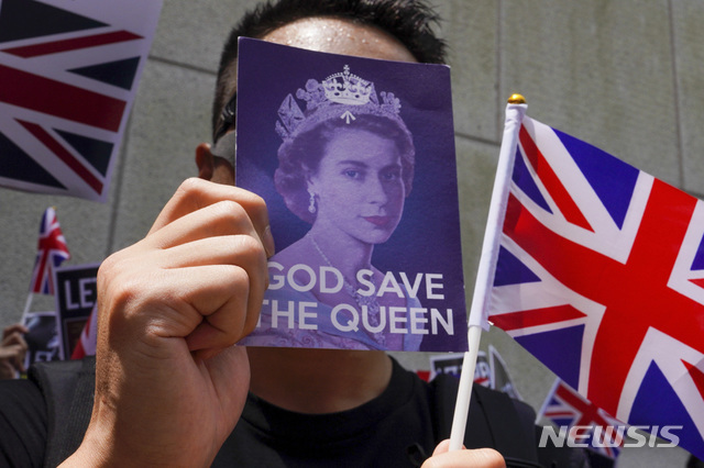 14일 홍콩 영국총영사관 밖에서 열린 시위에서 한 참가자가 '여왕 폐하 만세'라고 적힌 카드와 유니언잭을 흔들고 있다. 이들은 이들은 과거 식민지 지배국가였던 영국이 지난 1984년 서명한 홍콩반환협정에 따라 중국이 홍콩 자유, 자치권에 대한 약속을 지키도록 촉구할 것을 요구했다. 2019.09.15. (출처: 뉴시스)