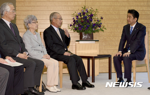 아베 신조 일본 총리(오른쪽)가 2017년 9월 도쿄의 총리 관저에서 북한에 의한 납치 피해자 가족들과 만나고 있다. (출처: 뉴시스)