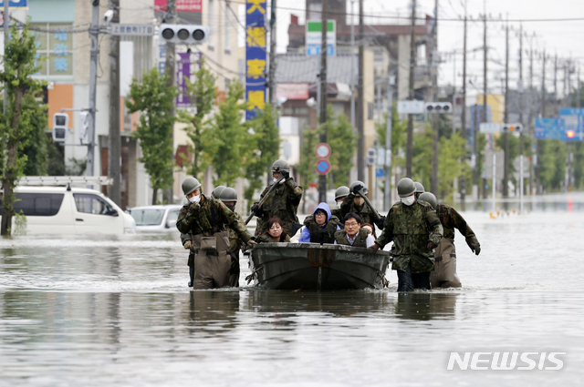 7일 일본 남부 후쿠오카현 오무타에서 도로가 폭우로 침수된 가운데 일본 자위대원들이 보트를 타고 주민들을 구조하고 있다. (출처: 뉴시스)