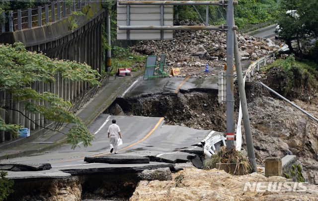 6일 일본 남부 구마모토현 구마무라에서 한 남성이 폭우로 심하게 파손된 도로를 걷고 있다. (출처: 뉴시스)