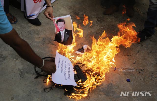 16일(현지시간) 인도 아마다바드에서 중국 반대 시위에 참여한 시위대가 시진핑 중국 국가주석의 사진을 불태우고 있다. 인도군은 중국과의 국경지대인 히말라야 고지대에서 중국군과의 충돌로 군 고위 장교를 포함해 20명이 숨졌다고 밝혔다. (출처: 뉴시스)