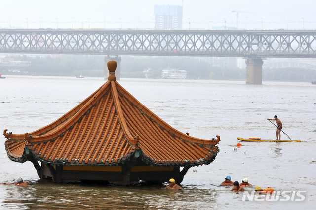 지난 8일 중국 후베이성 우한에서 범람한 양쯔강에 잠긴 정자를 주민들이 헤엄쳐 지나가고 있다. (출처: 뉴시스)