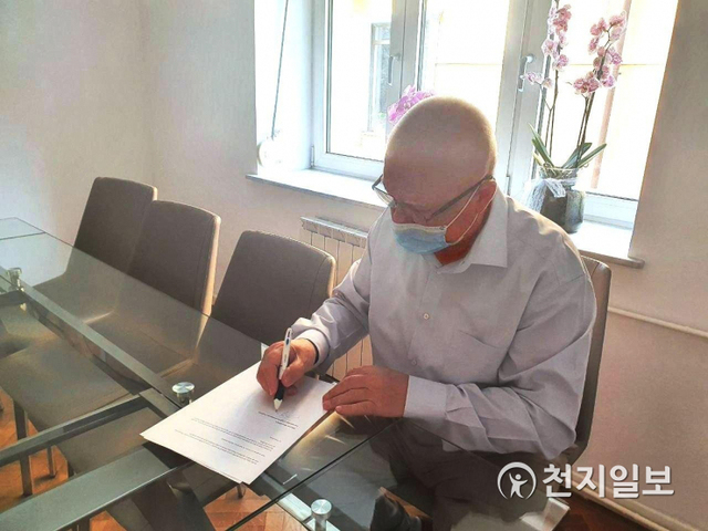 루마니아 헌법재판소에서 약 10년간 재직했던 페트레 러저루이우 전 판사가 24일 한국 정부에 촉구하는 성명서에 서명하고 있다. (제공: HWPL) ⓒ천지일보 2020.7.24