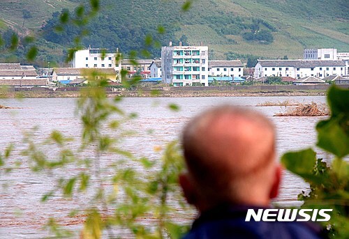 지난 2일 중국 지린성 투먼시 두만강나루터에 서 중국인이 북한 홍수피해 지역을 바라보고 있다. (출처: 뉴시스)