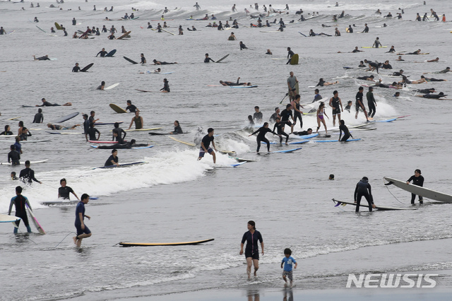 일본이 '바다의 날'로 휴일을 맞은 지난 23일 가나가와현 후지사와의 해변에서 사람들이 서핑을 즐기고 있다. (출처: 뉴시스)