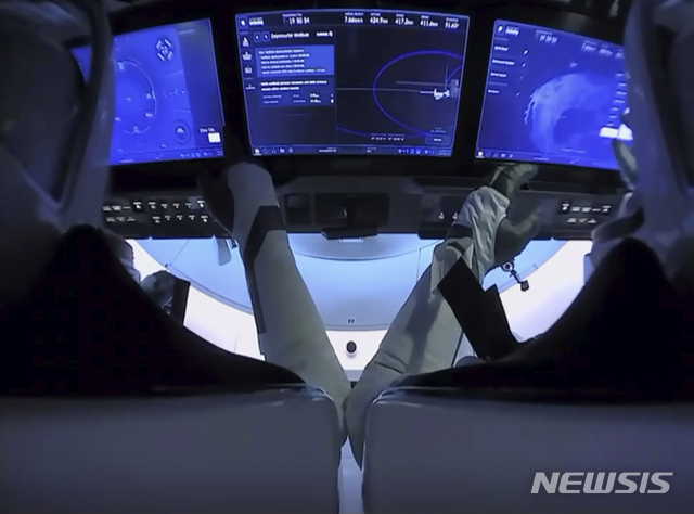[NASA·AP/뉴시스] 미국 우주비행사 더글러스 헐리(왼쪽)와 로버트 벤켄이 1일(현지시간) 크루 드래건 캡슐에 앉아 국제우주정거장(ISS)과의 분리를 준비하고 있다 .두 비행사들은 2일 멕시코만 해상에 착륙할 예정이다. 2020.08.02